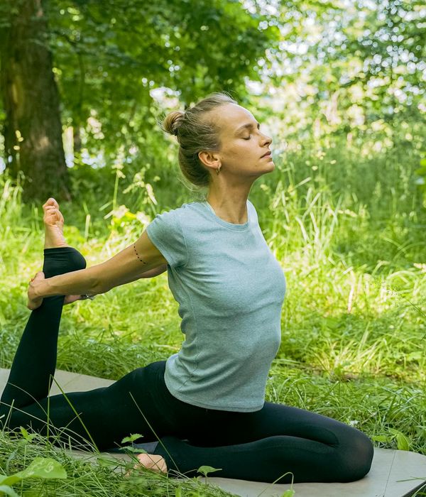 Woman performing a calm yoga stretch in a serene environment.